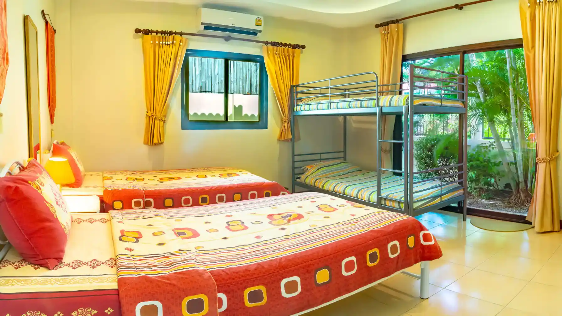 Bon Island Villa second bedroom with twin beds and bunk beds, patio doors to garden