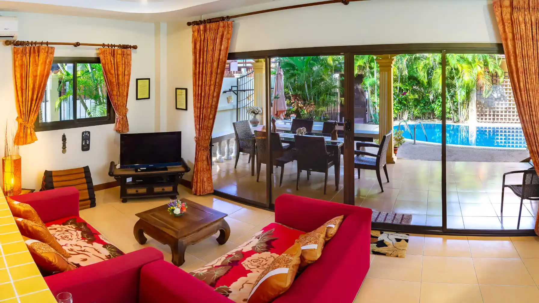 Bon Island Villa open-plan living area with patio doors to pool and tropical garden