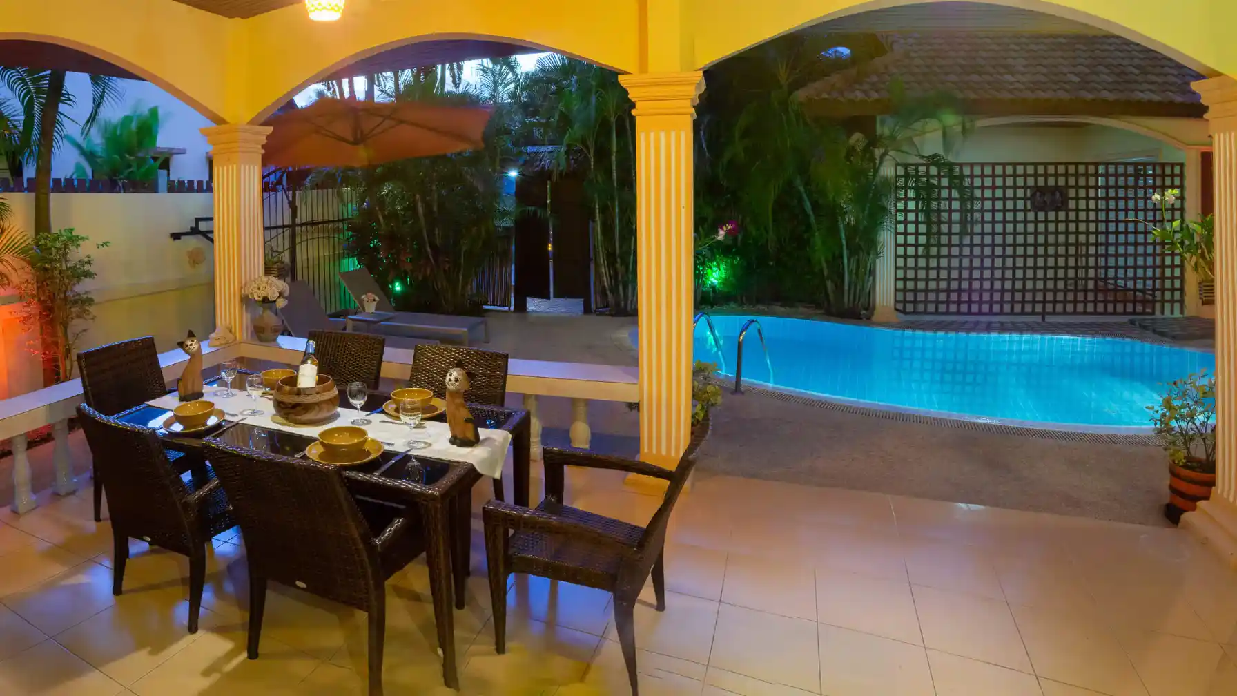 Bon Island Villa covered alfresco dining area with arched columns and pool view