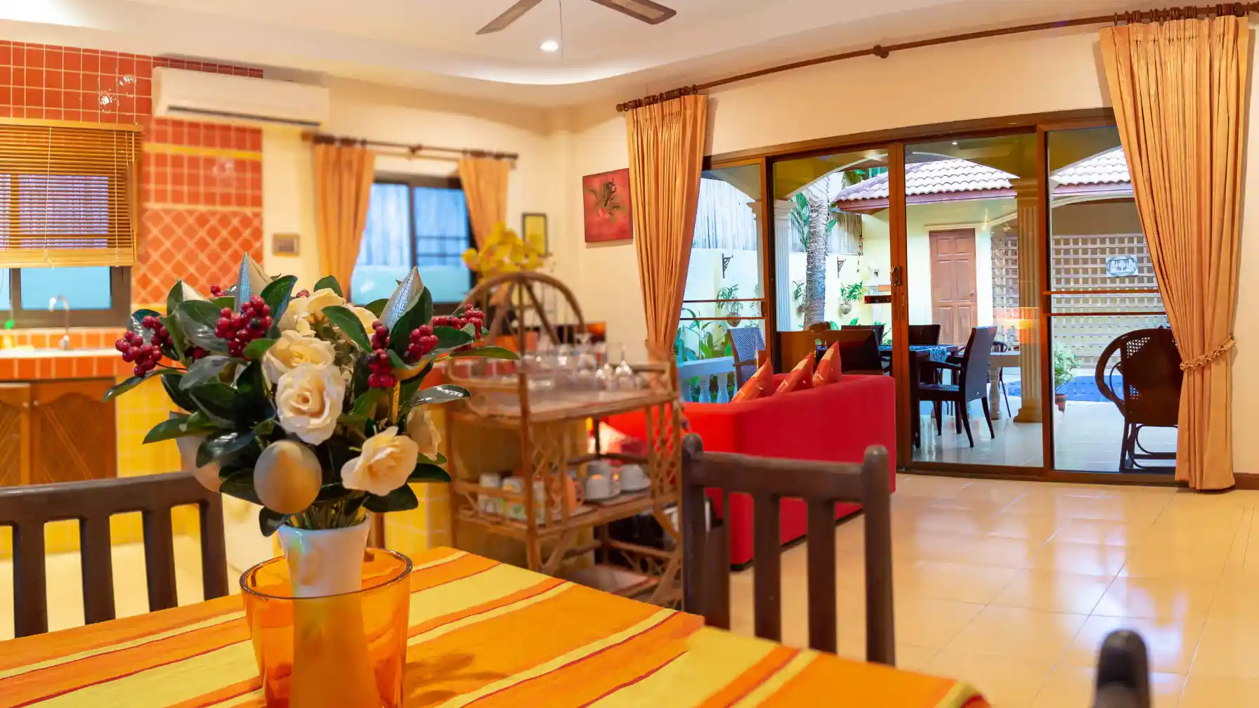 Coral Island Villa open-plan dining and living room with sliding doors to pool