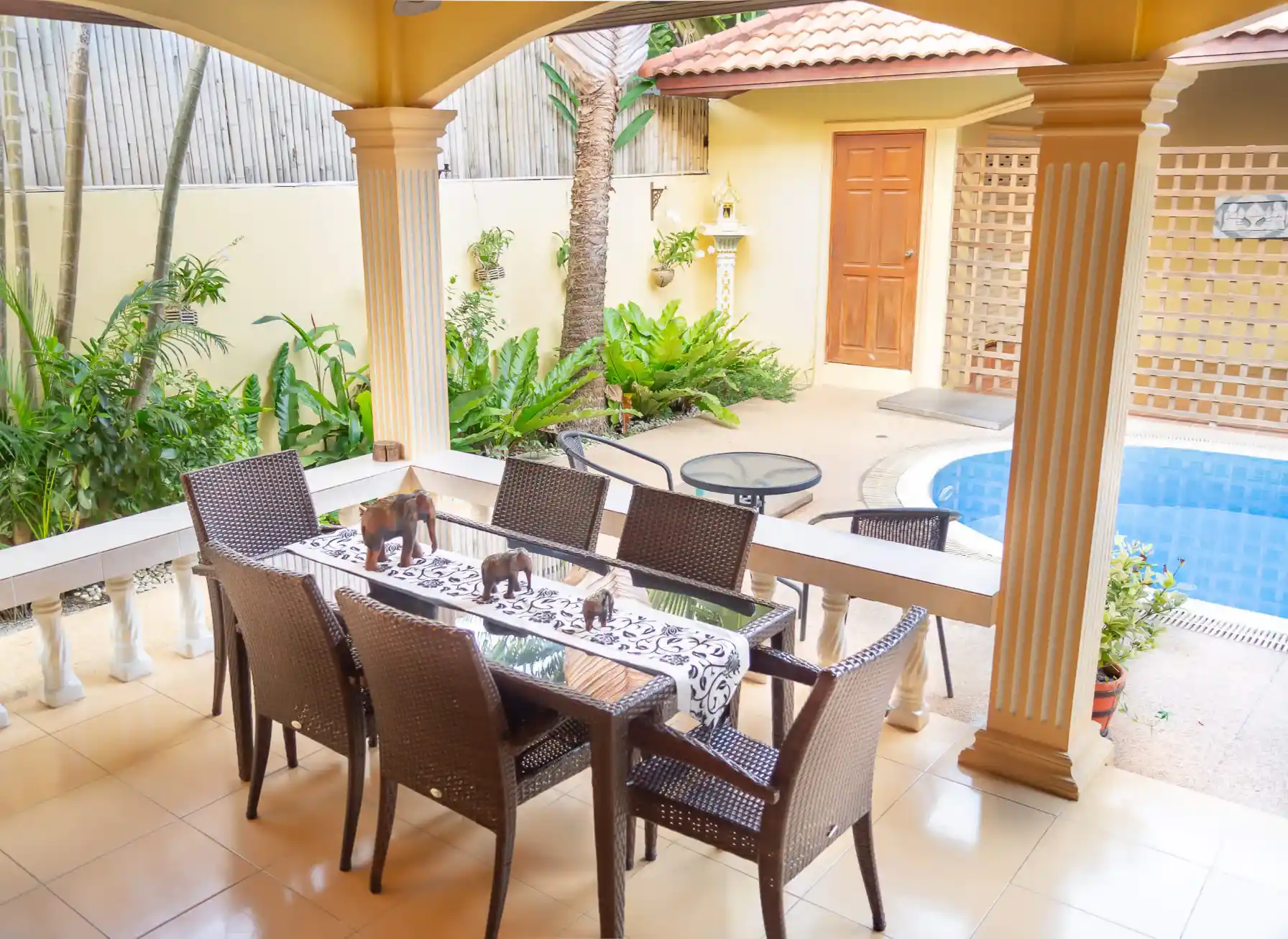 Coral Island Villa covered outdoor dining area with six-seat table and pool view