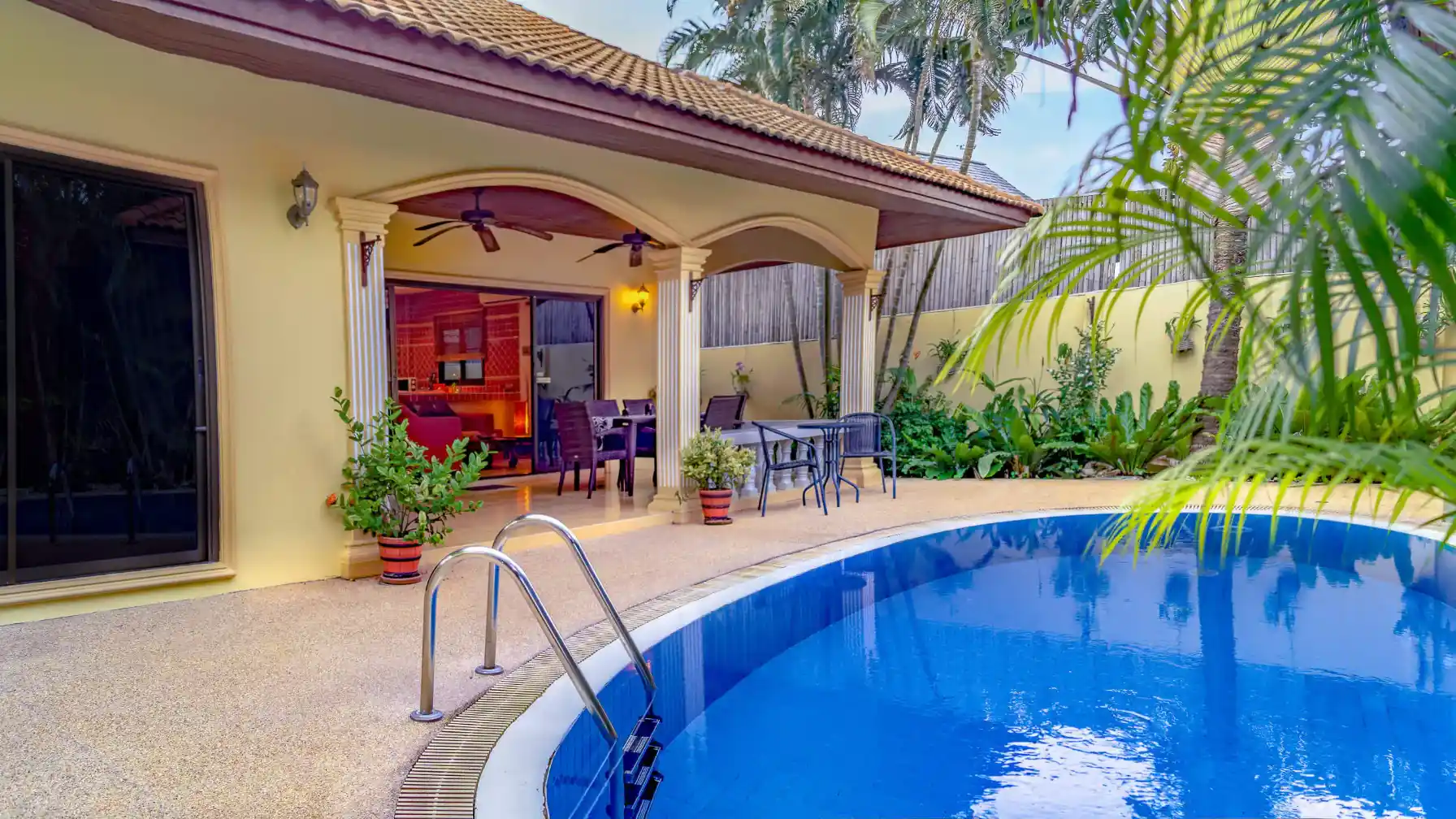 Coral Island Villa pool surrounded by lush tropical plants and palms